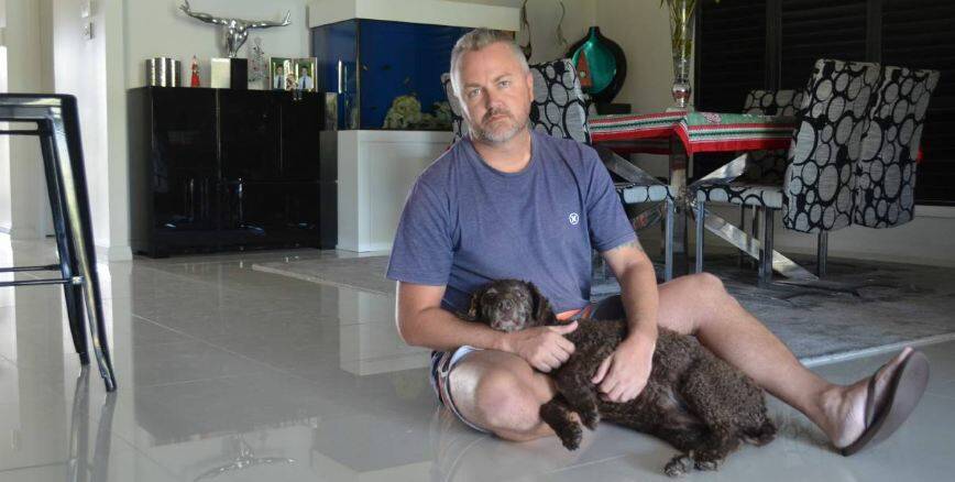 DISTRAUGHT: Nathan Wilson, pictured with curly haired retriever Charlotte at home in Fern Bay, was devastated by the death of his greyhound Baron. Picture: Sam Norris