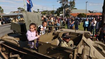 Hundreds lined the streets of Wangi Wangi for a military vehicle convoy before the town's Anzac Day service. Picture by Peter Lorimer   
