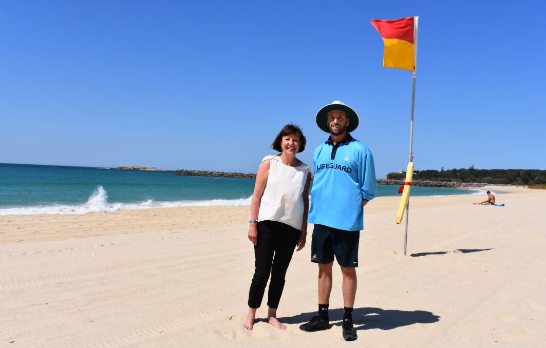 RED AND YELLOW: Mayor Kay Fraser with Lake Macquarie City Council lifeguard Troy Ham. Beach patrols begin this Saturday. Picture: Supplied.