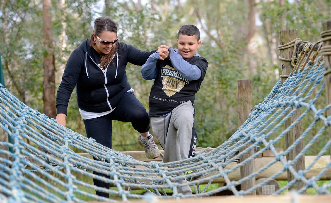 FAMILY FUN: Denzel and his mum Jaralee take on the rope bridge at last year's Camp Brainwave, at Yarramundi. This year's weekend camp is being held on Lake Macquarie, at Gwandalan, from today. Picture: Jeremy Piper