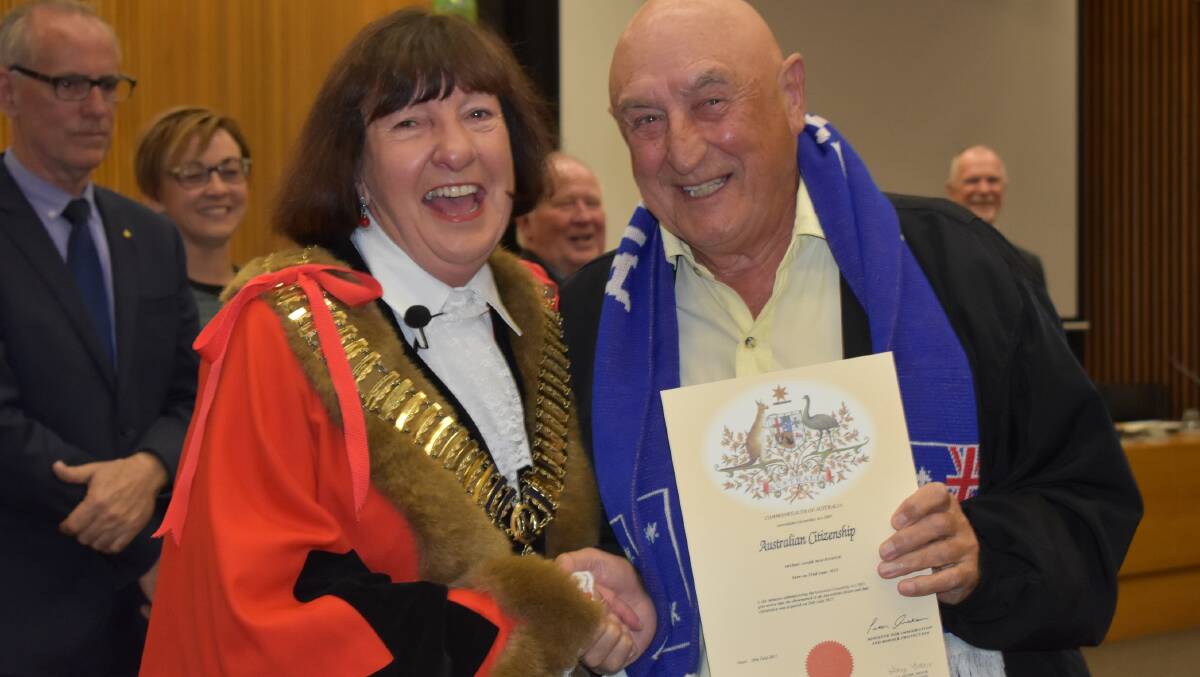 CRICKET FAN: Michael Mackenzie, of Toronto, receives his citizenship certificate from the Lake Macquarie mayor Kay Fraser. Picture: Supplied