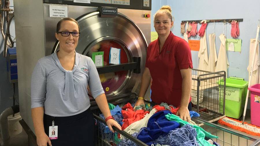 ANALYSIS: Lauren Hutton, left, with laundry staffer Mallanie Durazza. A workplace safety program saw wearable sensors attached to Anglican Care's laundry staff to determine the safety risks of specific tasks. Picture: Supplied