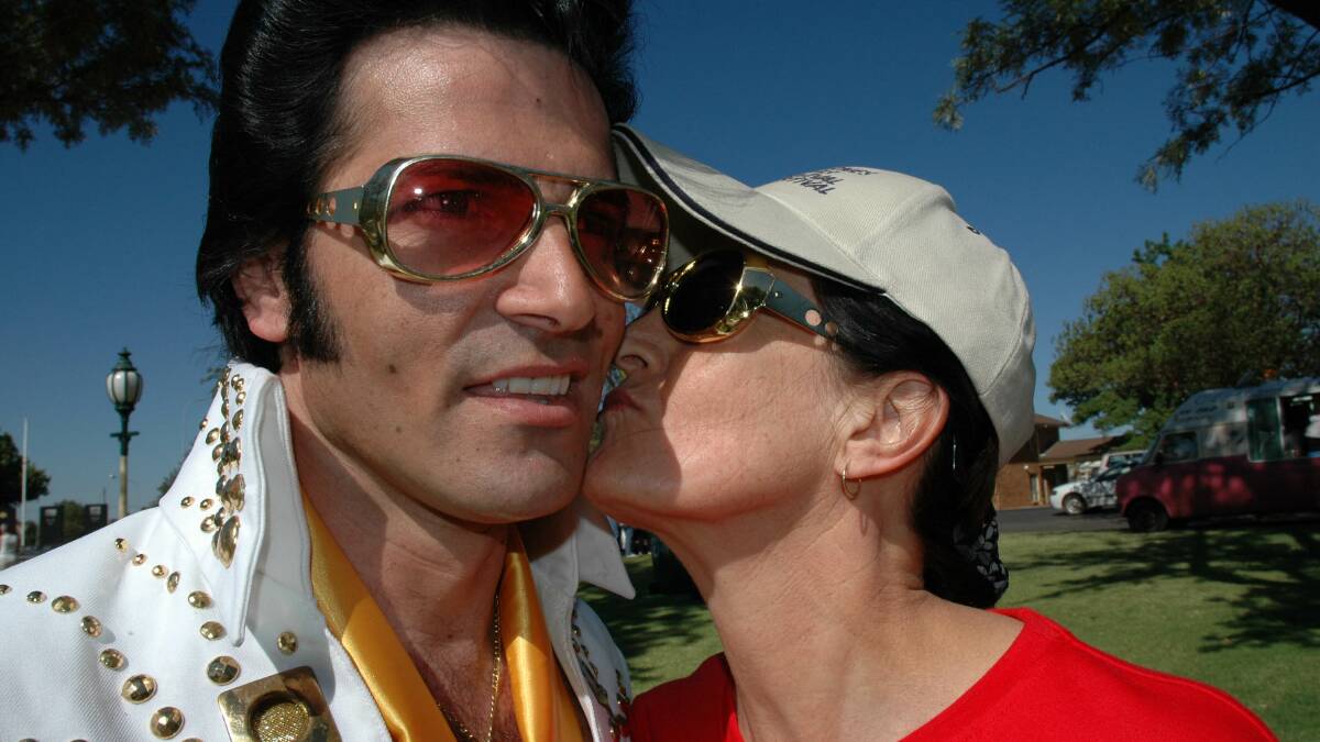 HUNK OF BURNING LOVE: Elvis impersonator gets a kiss from one of his fans.  