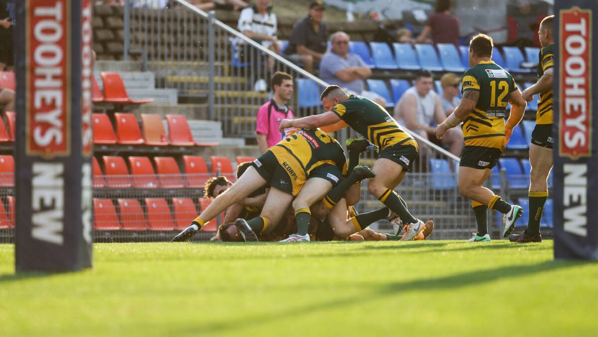 STACKS ON: Macquarie players embrace each other after Randall Briggs' intercept-try in the closing stages of Saturday's decider. Picture: Jonathan Carroll
