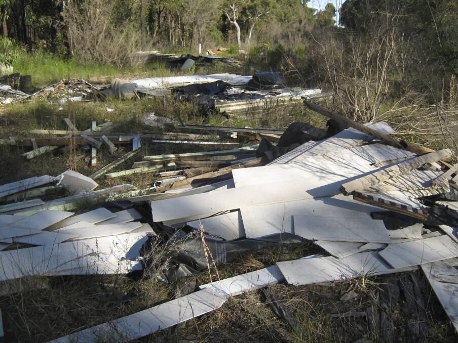 HAZARD: A pile of rubbish including asbestos sheeting found dumped in bushland off Wyee Road last month.