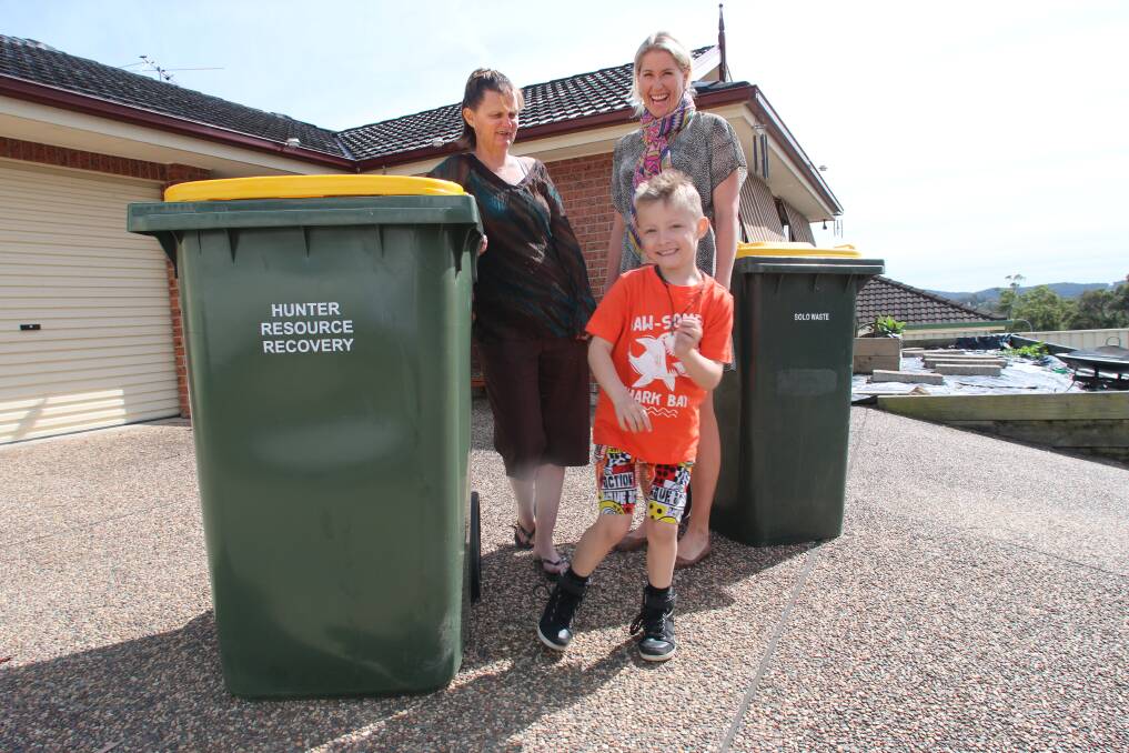MOORE SPACE: Elizabeth Moore, left, and son Ayden are loving their 360-litre recycling bin, which has replaced the 240-litre model, rear. They are pictured with council waste officer Bridget Saint. Picture: David Stewart