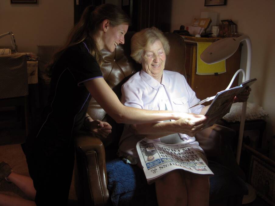 HOME VISIT: Ivy Dalton, of Marks Point, is visited by Royal Society for the Blind occupational therapist Laura Boer. They are pictured with the magnifying light the RSB provided for Ms Dalton to use while reading and crocheting.