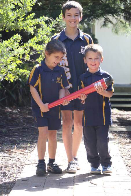 MILESTONE: Dora Creek Public School captain Luke Evans, (year 6), at the back, leads Jessica Deal (year 1) and Rhys Ferguson (kindergarten), practising for the torch relay.