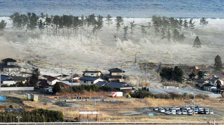 Waves from a tsunami hit residences after a powerful earthquake in Natori, Miyagi prefecture (state), Japan, Friday, March 11, 2011.  (AP Photo/Kyodo News) 