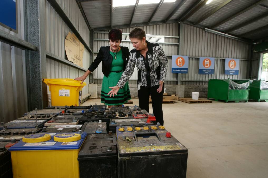 NO PROBLEM: Environment Minister Robyn Parker, left, with Lake Macquarie City Council's operations director Amanda Colbey and an array of car batteries to be recycled at the Awaba facility. Picture: Peter Stoop