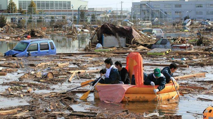 Civil Aviation College students and other people use a rubber raft to get food and other items from their dormitory that submerged following a catastrophic earthquake and tsunami, in Sendai, northeastern Japan, on Sunday March 13, 2011. (AP Photo/Mainichi Shimbun, Naotsune Umemura) 