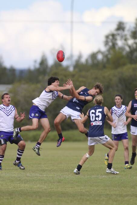 UP THERE: Lake Macquarie's Damon Barry leaps high to contest possession against Newcastle City, while his Dockers team-mates Brad Farrell, left, and Tim Wells wait for the crumbs. Picture: David Stewart