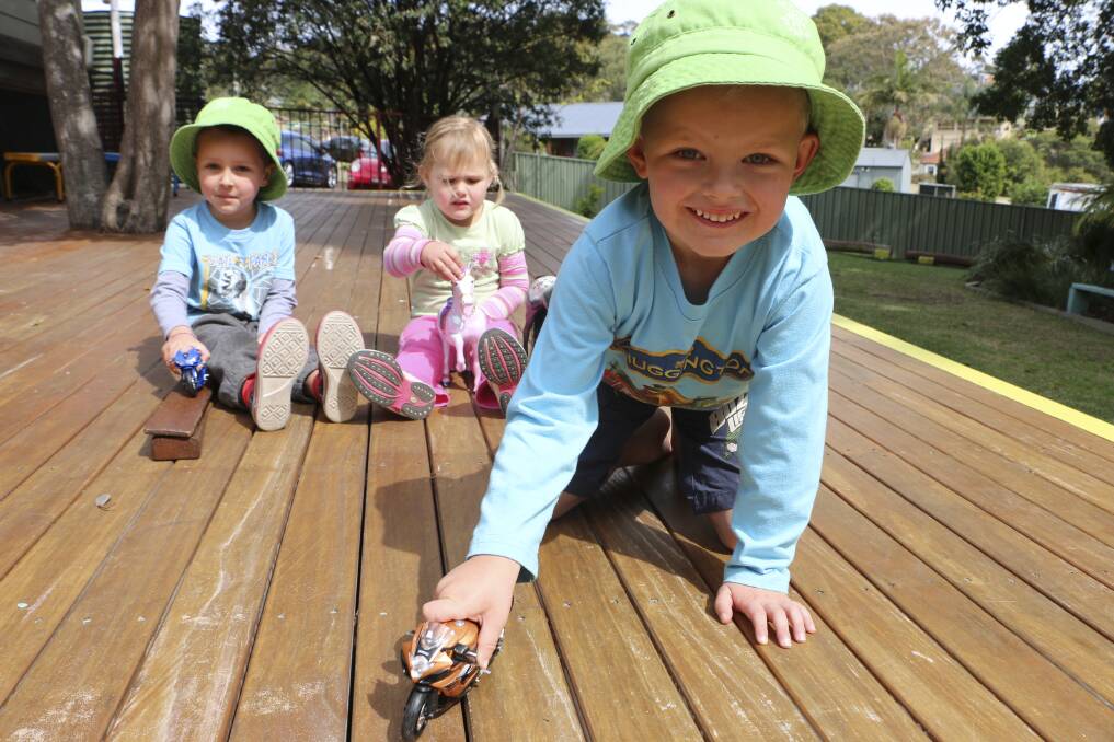 HELP NEEDED: Kaizen Ruse, front, plays with his sister Lexi, and Tynan Field, at Peter Pan Preschool, Wangi Wangi, on the timber deck that is slated for maintenance next Saturday. Picture: David Stewart