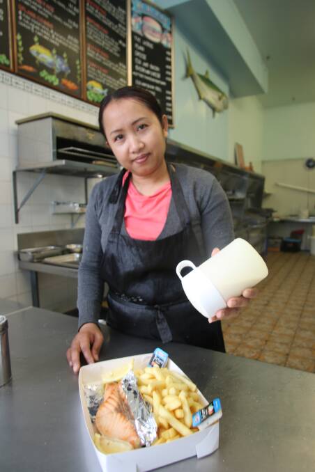 LOCAL HOPE: Sandy Chheur of Splash Seafood Toronto, serves up a grilled salmon and chips lunch for a customer on Friday. Picture: David Stewart
