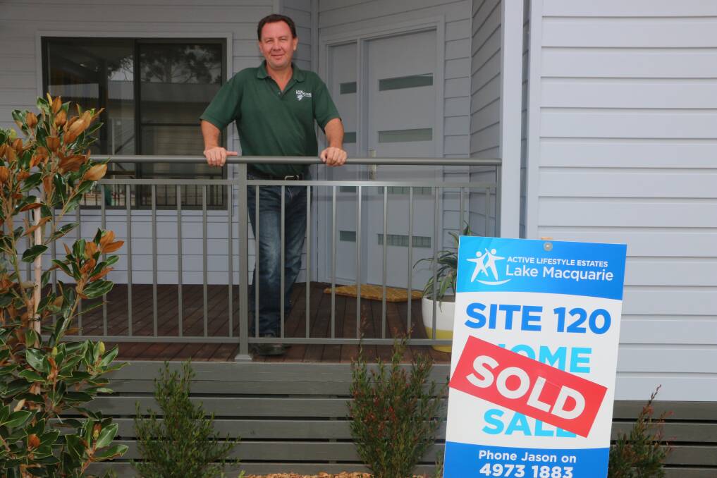 GOING FAST: Jason Webb out the front of one of the newly sold homes at Morisset. Picture: Jamieson Murphy