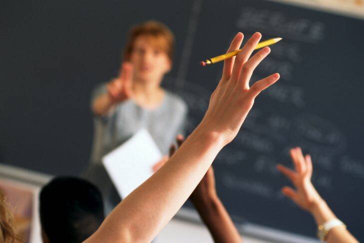 Teacher pointing to raised hands in classroom boarding school

Generic