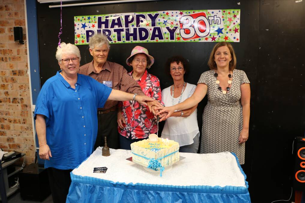 MILESTONE: Cutting the cake are, from left, founding committee member Ros Chapman, long-serving volunteers Brian and Sylvia Byles, former manager Julia Sugden, and manager Vivienne Bruce. Picture: David Stewart