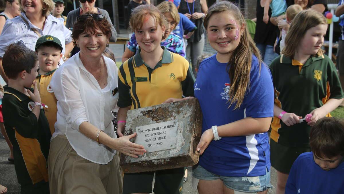 PUPIL PREDICTIONS: Principal Sharon McFarlane and school prefects Amber Berry, centre, and Taylor Crowe, remove the 1988 time capsule from the ground. Picture: David Stewart