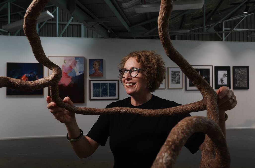 Newcastle Art Space program coordinator Madeleine Snow with a work by Jaymie Malley at the Hunter Emerging Art Prize installation that opens on Friday. Picture by Simone De Peak