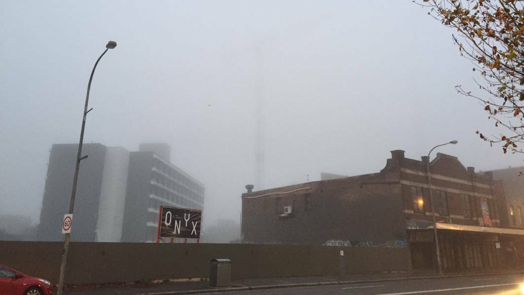 A crane can barely be seen through the fog in Newcastle. Picture: Jessica Brown