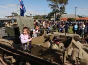 Hundreds lined the streets of Wangi Wangi for a military vehicle convoy before the town's Anzac Day service. Picture by Peter Lorimer   