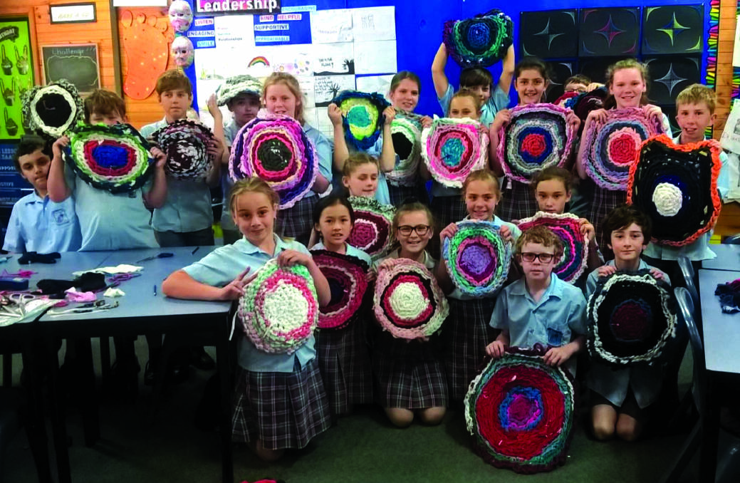 CRAFTY: St Joseph's Primary School students display their rugs made from discarded clothes.