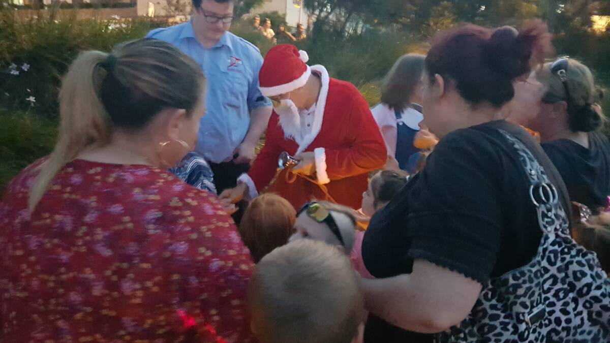 POPULAR: Santa hands out lollies to the crowd.