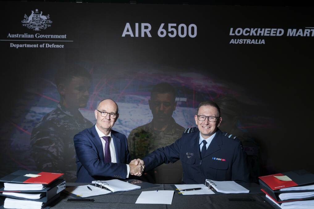 Chief Executive Officer, Lockheed Martin Australia, Mr Warren McDonald (left) and Head Air Defence and Space Systems Division, Air Vice-Marshal David Scheul, shake hands, following the signing of the Head of Agreement contract with Defence and Lockheed Martin Australia, that will deliver the Australian Defence Forces Joint Air Battle Management System (JABMS).