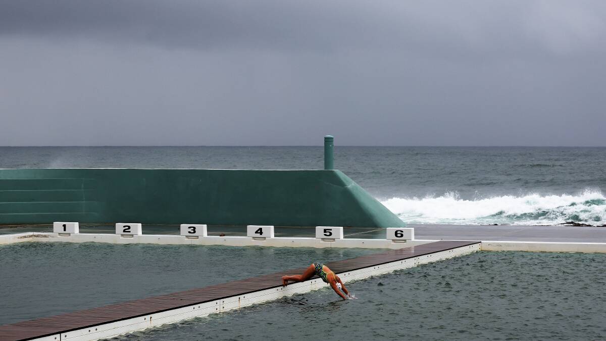 A swimmer braved the rain at Newcastle Ocean Baths on April 20. Picture by Peter Lorimer