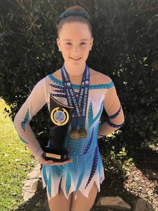 CHAMPION: Emma Doughty, 13, of Advance Academy of Gymnastics and Acrobatics, in Toronto, with her medal and trophy haul. Picture: Supplied