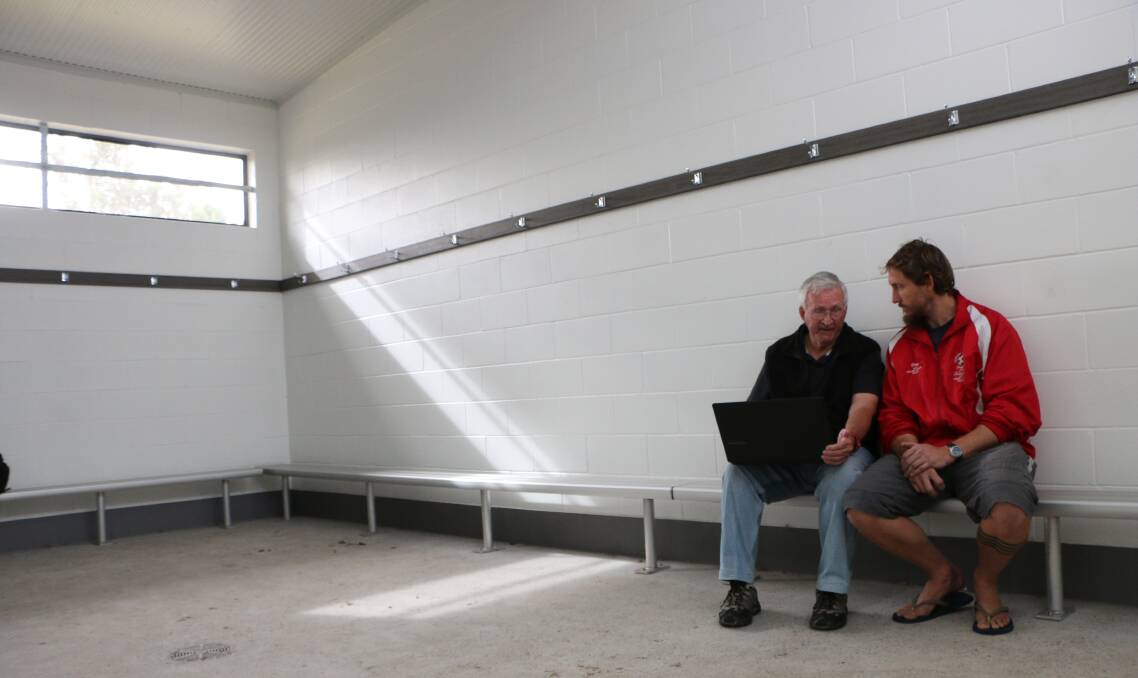 LIFE MEMBERS: Jim Reeves and Morisset United Football Club president Dainis Masens reminisce over old club photos in the Auston Oval change rooms ahead of this Sunday's Old Boys Day. Picture: David Stewart
