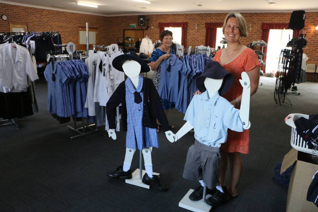 WELL DRESSED: Georgina O'Reilly, front, and Joan McDonald among the stock at All About Uniforms, in Cooranbong Community Centre, 614 Freemans Drive. Picture: David Stewart