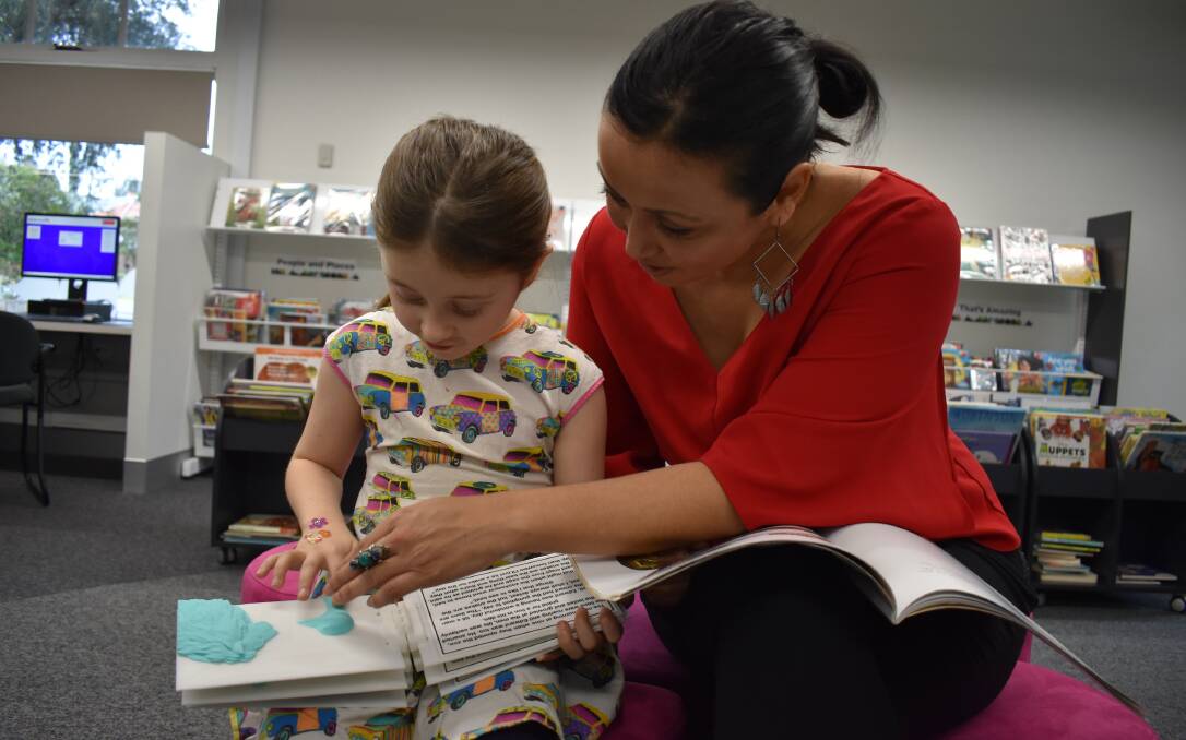 FEELS GOOD: Zanthe and Angie explore a 3D book at the Speers Point Library. Picture: Supplied.