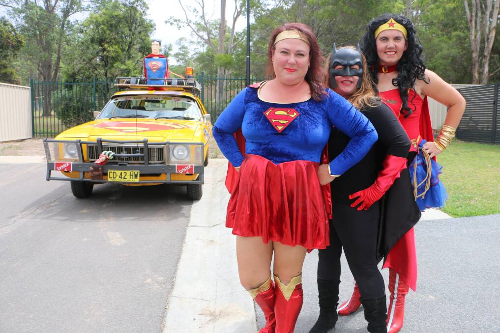 CAPED CREW: Kylie McNaughton (Super Woman), Lil Rhodes (Bat Girl), and Lundi Laruffa (Wonder Woman) with their 1976-model Holden HX. Picture: David Stewart