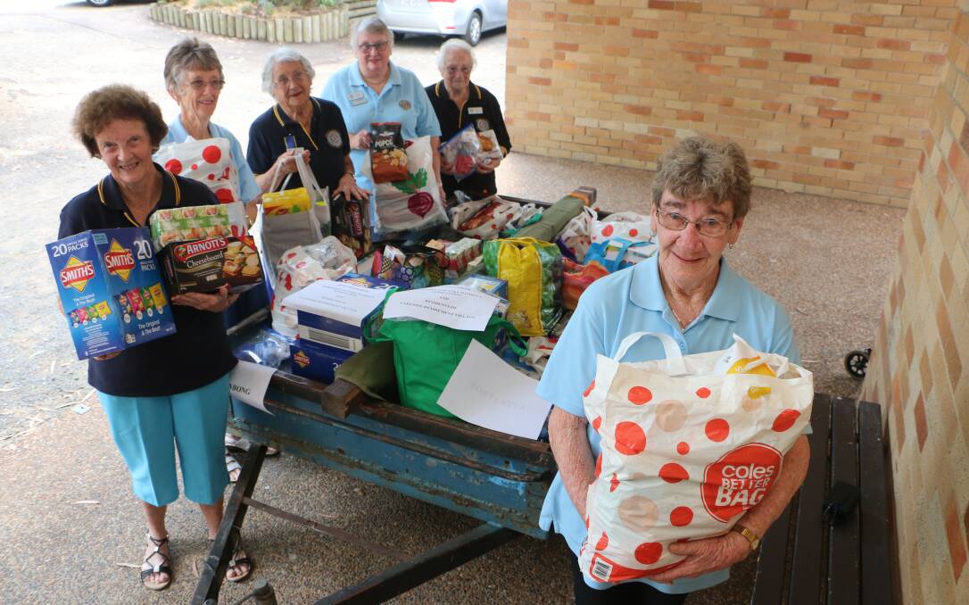 OUR PLEASURE: Branch secretary Lynne Radley, right, with fellow Morisset Country Women's Association members and the trailer full of goodies. Picture: David Stewart 