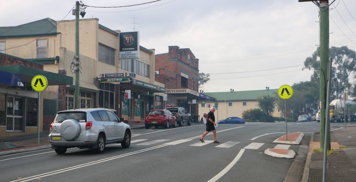 MADE IT: A man successfully negotiates the pedestrian crossing on Dora Street, Morisset, on Friday. Traffic lights are being installed at the location in an effort to improve pedestrian safety. Picture: David Stewart