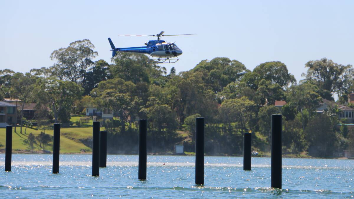QUESTIONS: A helicopter approaches the site of the planned Trinity Point marina during acoustic testing for the proposed helipad. Picture: David Stewart