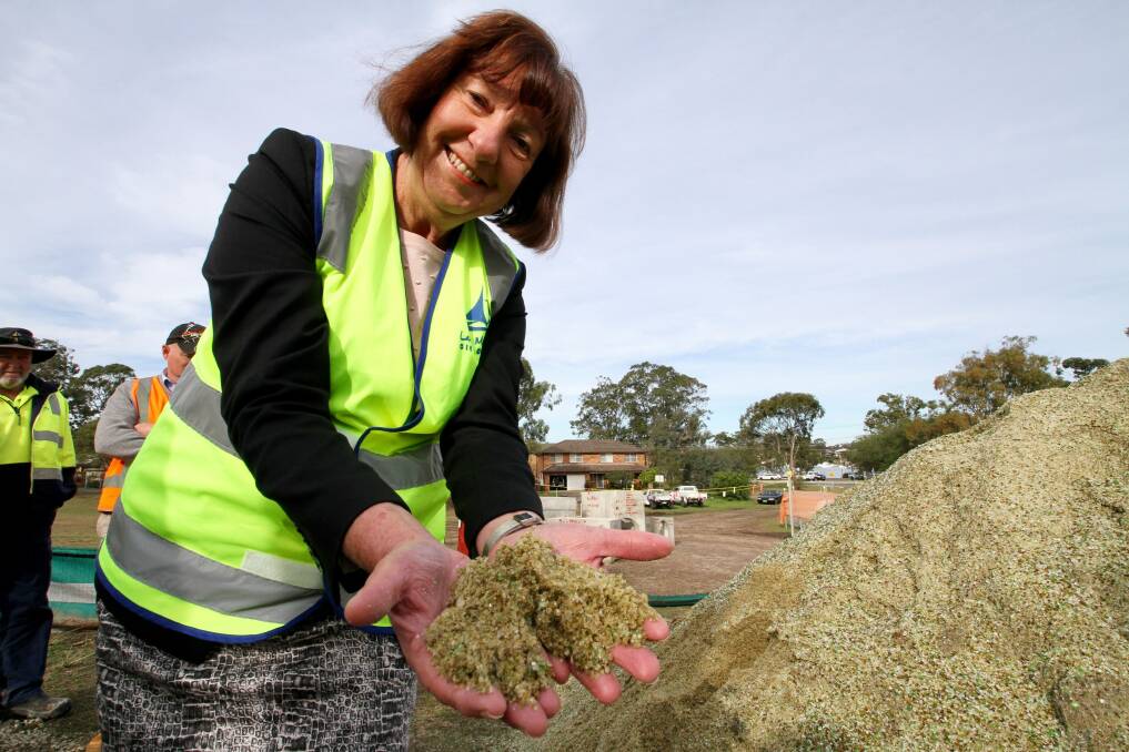 Mayor Kay Fraser samples the crushed glass at the drainage project at Fishing Point last year. Picture: Supplied