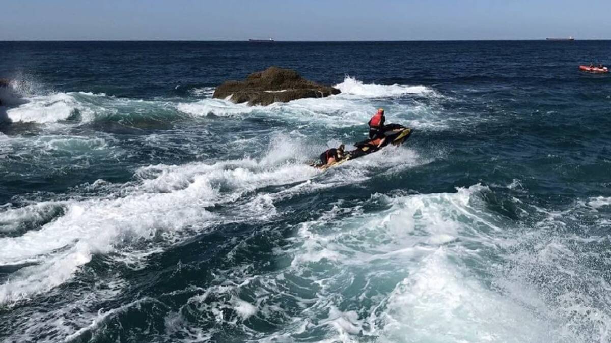 SAFELY OUT: The Lakes Surf Club jetski powers through the swirling waters at Snapper Point to rescue teenagers trapped in a sea cave on the rising tide in September. Picture: Supplied