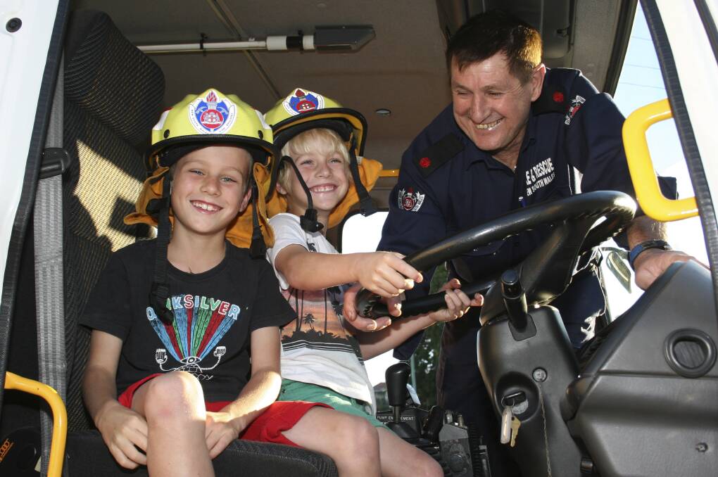 Jim Reddish, pictured in 2013, with grandsons James, left, and Lucas, in a fire truck for a story to preview open day at the station. Picture: David Stewart