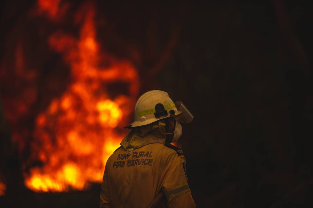 HOMES THREATENED: Rural Fire Service crews face the onslaught of a blaze that took hold at Charmhaven on New Year's Eve. Picture: Marina Neil