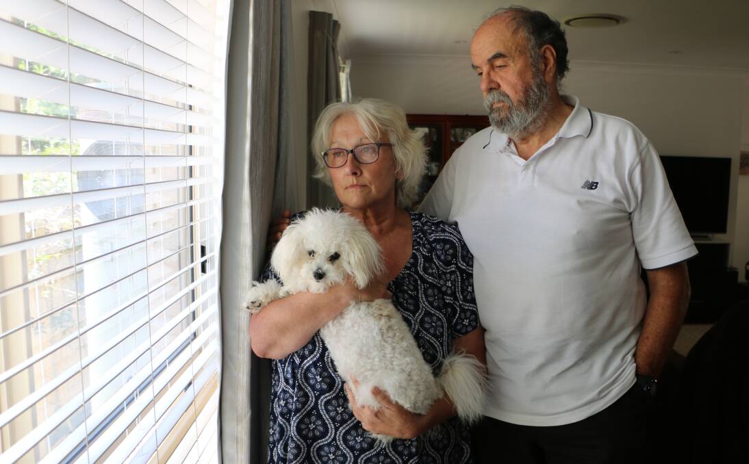 GRIEF-STRICKEN: Coralie and Allan Davis at their Buttaba home this week with puppy Tashi. The couple said their dog Annie's death at a Cooranbong boarding kennel was "a terrible accident". Picture: David Stewart
