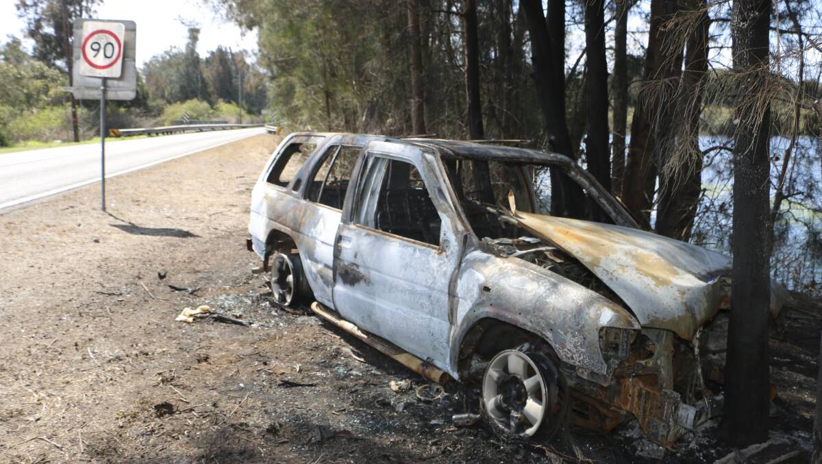 EYESORE: A reader says burnt-out cars, such as this one at Dora Creek, are a bushfire threat, but those who set the cars alight are an added concern. Picture: Jamieson Murphy.