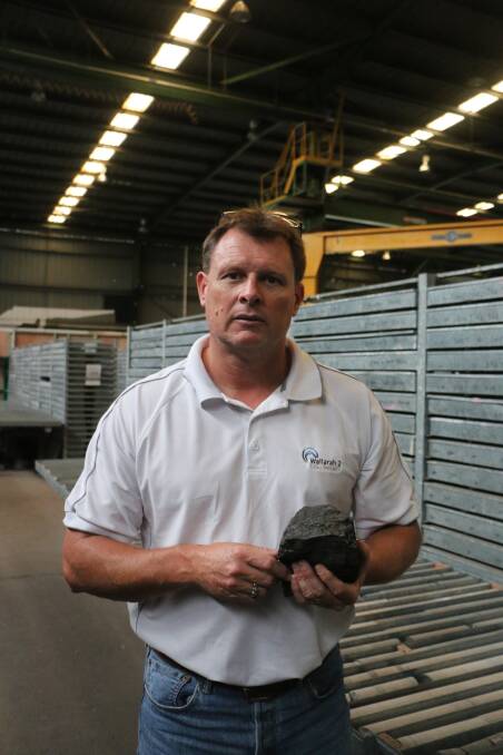 RESOURCE: Wallarah 2 project manager Kenny Barry with a chunk of the coal the company plans to mine from under the valleys west of Wyong, near the border with Lake Macquarie. Picture: David Stewart