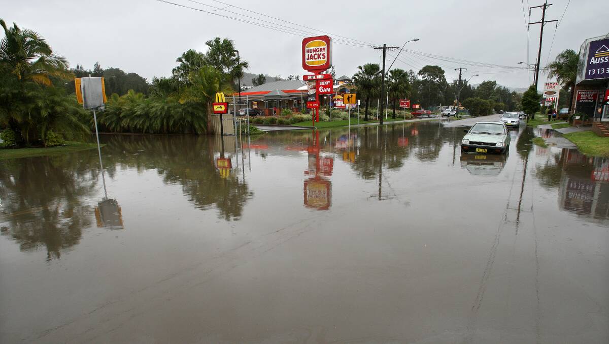 GOING UNDER: Anzac Road, at Tuggerah, has been closed again due to flooding. This photograph was taken in 2007. A man has been criticised by police for riding a jet ski down the road yesterday. Picture: Phil Hearne
