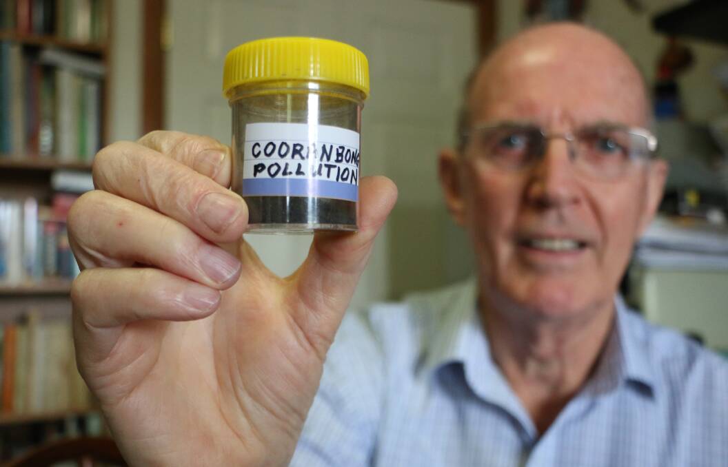 WORRYING SAMPLE: Dr Terry Annable with a container of the ultra-fine black particles he said were regularly deposited on his house, car and garden at Cooranbong. Dr Annable said the particles had escaped the filtering system in place at Eraring's coal-fired  power station. Picture: David Stewart