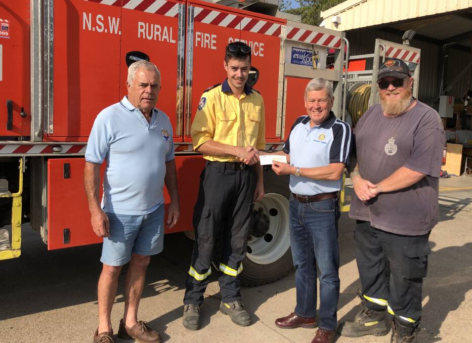 DONATION: The Rotary Club of Toronto Sunrise's Tim Turner preents the $500 cheque to Awaba RFS brigade captain Callun Tracy as Rotarian Geoff Hurt, left, and RFS crew member Neil Wood look on. Picture: Supplied.