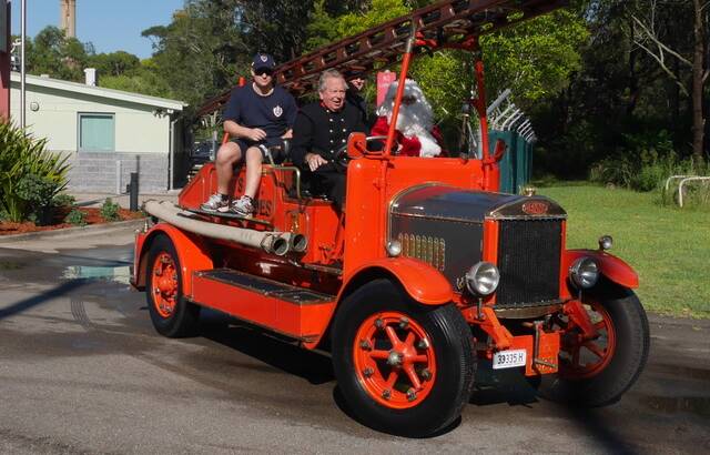 SPECIAL DELIVERY: Santa with his firefighter mates aboard the 1927 Dennis fire truck during last year's lolly run. Picture: Supplied
