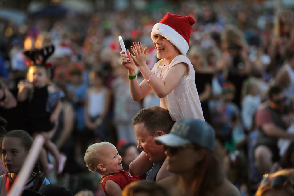 LAUGHING ALL THE WAY: Tristan Most with his daughters, Evelyn, 7, and Connie, 15 months, of Cessnock, at Speers Point for the carols. Pictures: Marina Neil