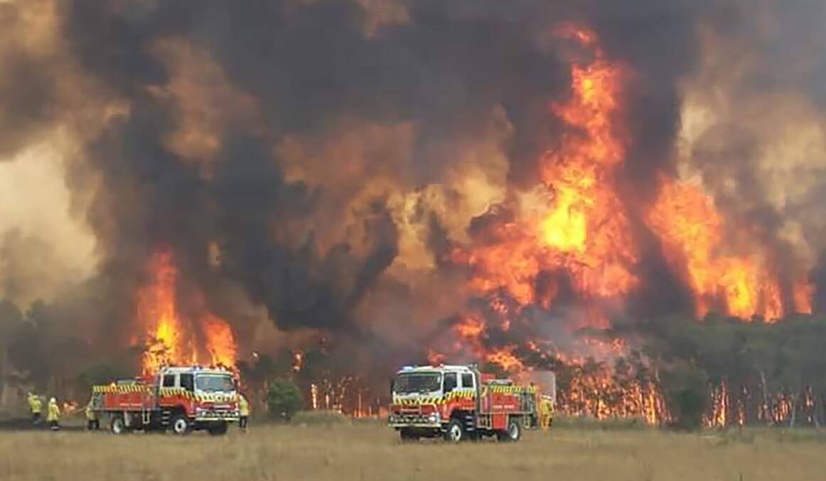 OUT OF CONTROL: Firefighters protecting homes around Charmhaven on Tuesday, December 31. Picture: Twitter @NSWRFS 